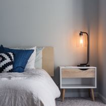 Bedroom with a lamp on a wooden bedside table