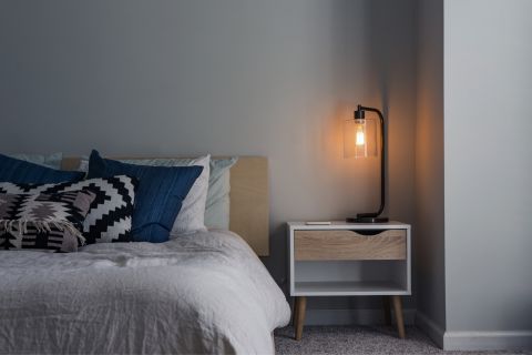 Bedroom with a lamp on a wooden bedside table
